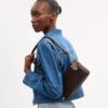 Audrey-crossbody-veske i Signature Canvas