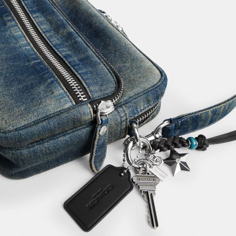 Dakota-crossbody-veske i regenerativ bomullsdenim med anheng