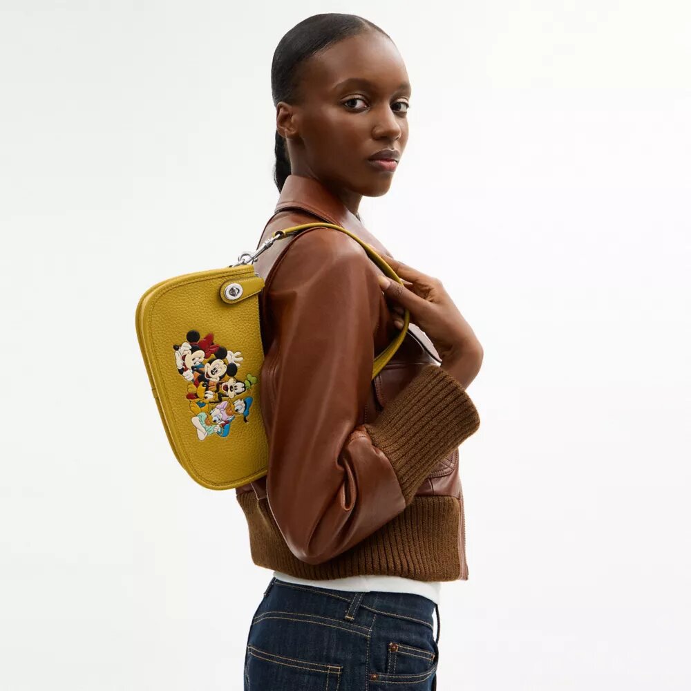 Disney X Coach Swinger-veske i regenerativt skinn med Mikke Mus og vennene hans