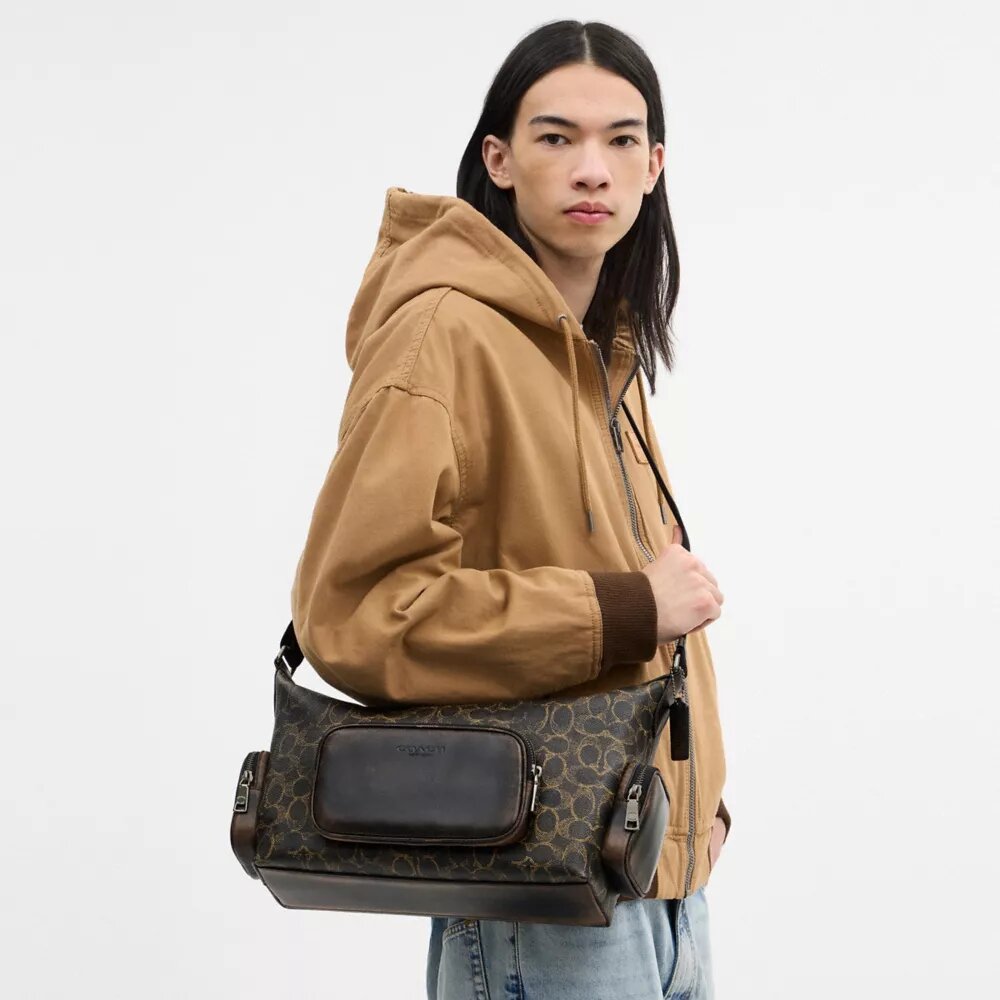Finn-crossbody-veske med lommer i «Loved Signature Canvas»-kanvas