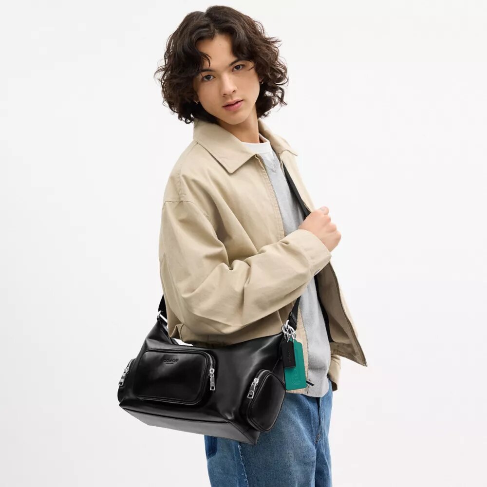 Finn-crossbody-veske med lommer og anheng
