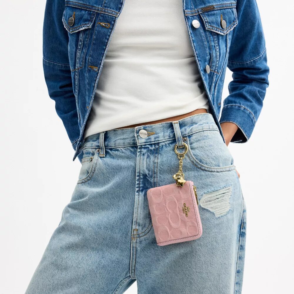 Liten hjørnelommebok med glidelås i Signature-denim med anheng