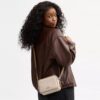 Mini Carey-crossbody-veske i Signature Canvas