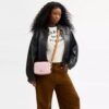 Mini Carey-crossbody-veske med kryssrem i Signature Canvas med anheng
