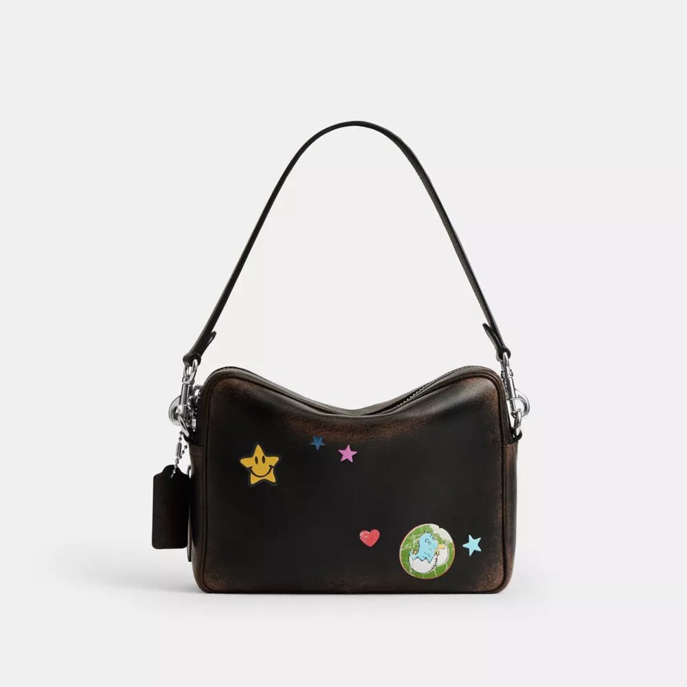 Rexy 10-årsdag Dakota-crossbody-veske i «Loved Leather» med klistremerketrykk