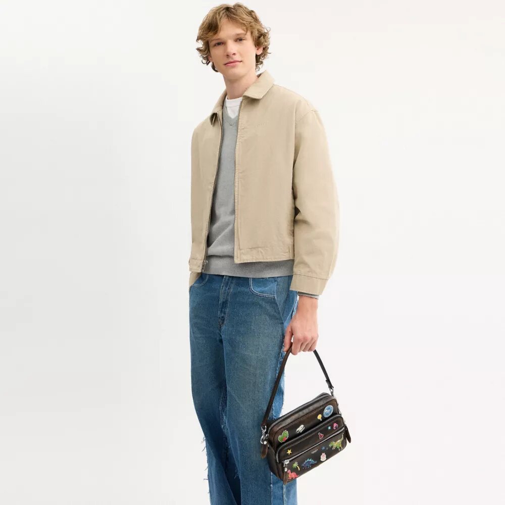 Rexy 10-årsdag Dakota-crossbody-veske i «Loved Leather» med klistremerketrykk