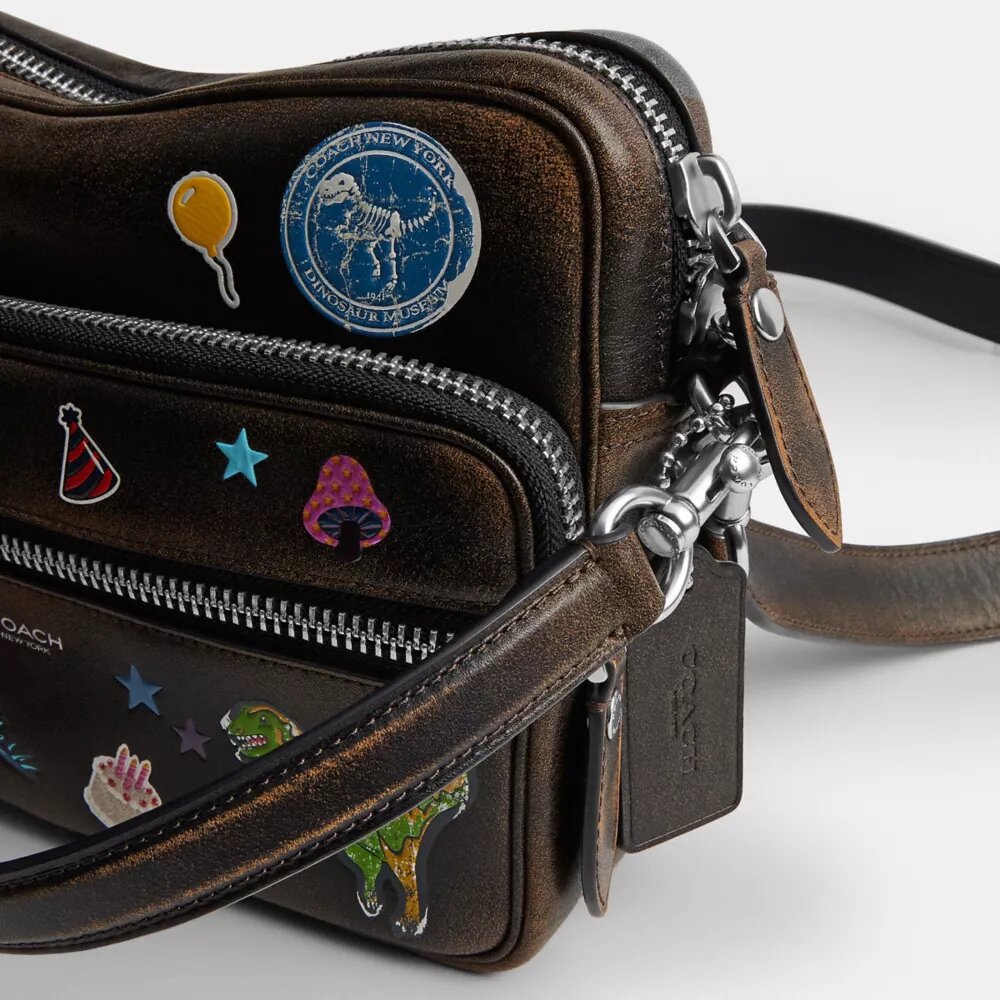 Rexy 10-årsdag Dakota-crossbody-veske i «Loved Leather» med klistremerketrykk